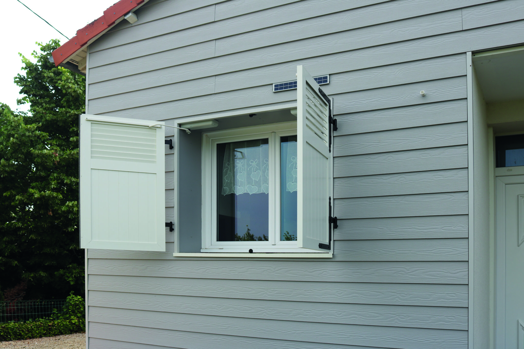 fenêtre avec volets blanc en aluminium semi ouverts