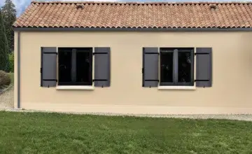 maison avec des volets en aluminium gris présentés ouverts