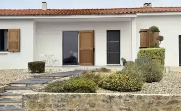 façade de maison dont les fenêtres et portes fenêtres sont équipées de volets battants en bois centauri